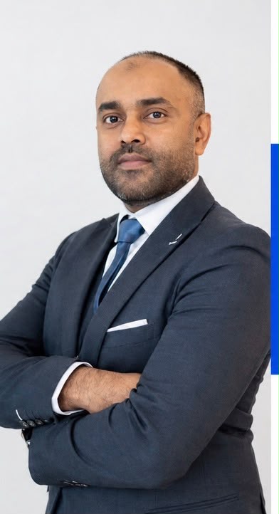 Shafan Cader, RERA Certified Broker in Dubai, wearing a dark suit and blue tie